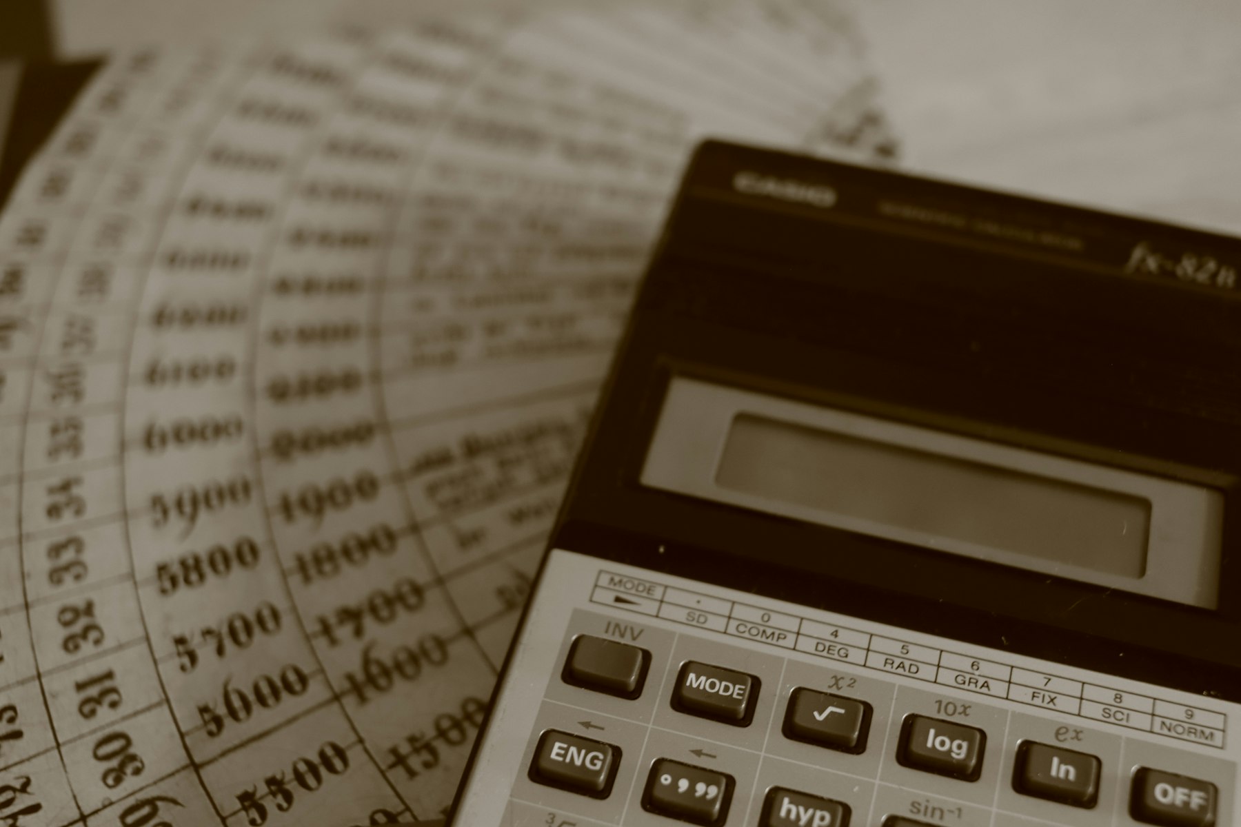 A calculator resting on printed ledger sheets