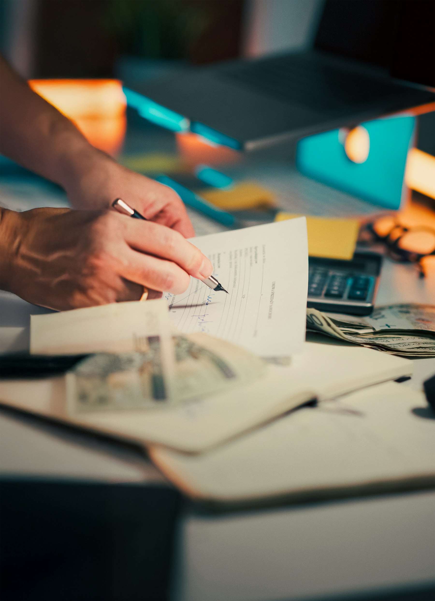 A hand signing incorporation documents at a desk
